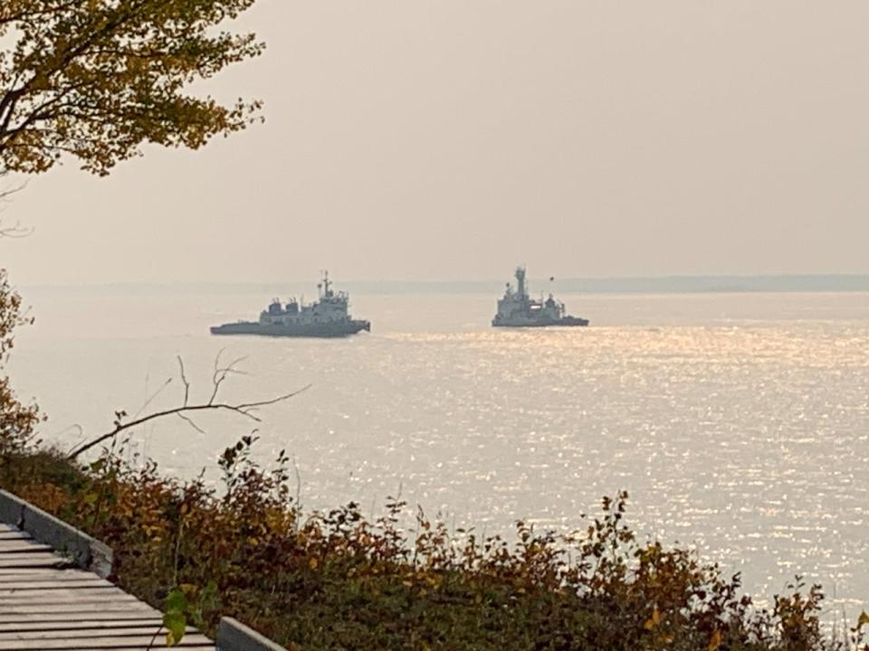 A tugboat (on the left) operated by Marine Transportation Services grounded itself in the Mackenzie River near Fort Providence earlier this month. Other boats worked to free it; it was eventually on September 14.