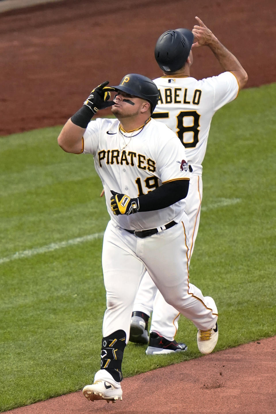 Pittsburgh Pirates' Daniel Vogelbach (19) celebrates with third base coach Mike Rabelo after hitting a solo home run off Cincinnati Reds starting pitcher Luis Castillo during the fourth inning of a baseball game in Pittsburgh, Saturday, May 14, 2022. (AP Photo/Gene J. Puskar)