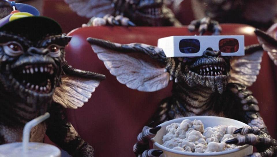 The Gremlins tuck into a bucket of popcorn. (Warner Bros.)