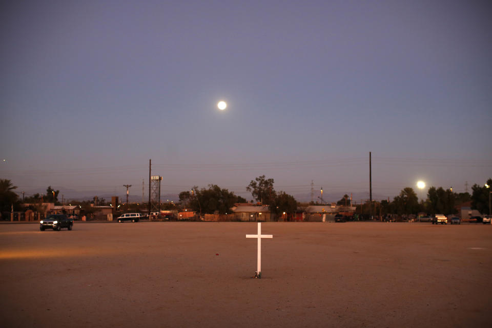 In this Feb. 8, 2020, photo, a cross stands next to a baseball field as the day ends in Guadalupe, Ariz. Founded by Yaqui Indian refugees from south of the border more than a century ago, the town named for Mexico's patron saint, Our Lady of Guadalupe, is proud of its history but wary of outsiders as it prepares for the 2020 Census count its leaders hope will help better fund a $12 million budget to fill potholes and mend aging sewage lines. (AP Photo/Dario Lopez-MIlls)