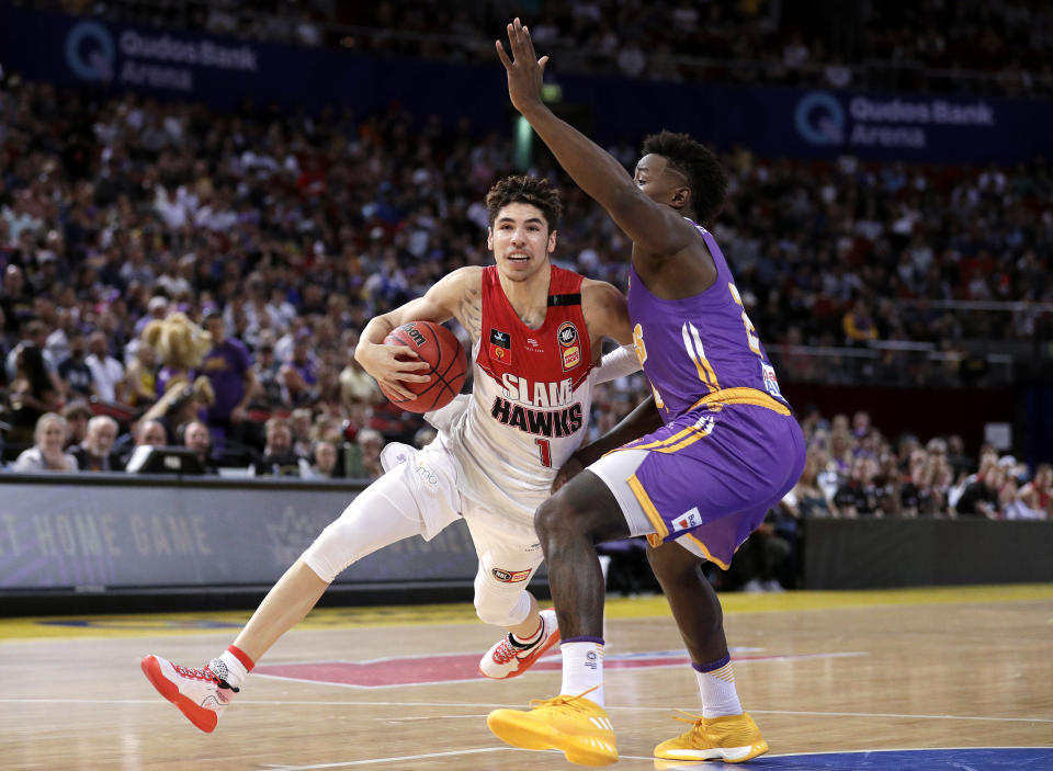 LaMelo Ball of the Illawarra Hawks drives past Jae'Sean Tate of the Sydney Kings during their game in the Australian Basketball League in Sydney, Sunday, Nov. 17, 2019. (AP Photo/Rick Rycroft)