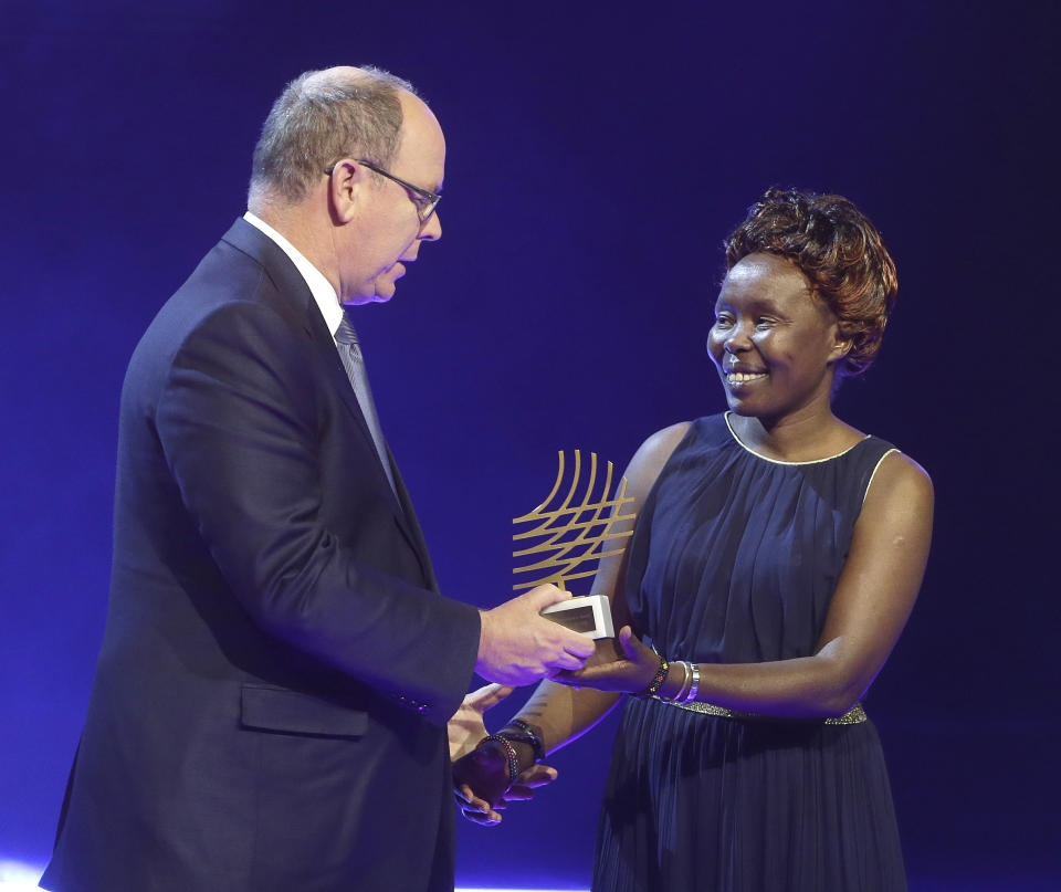 FILE - In this Friday, Dec. 2, 2016 file photo Prince Albert II of Monaco, left, presents Kenyan distance runner Tegla Loroupe with the 2016 President Award at the 2016 World Athletics Gala Awards in Monaco. Laroupe, currently the chief of mission for the IOC's Refugee Olympic Team, has tested positive for COVID-19, two people with knowledge of her condition have told The Associated Press. (AP Photo/Claude Paris)