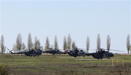 Russian military helicopters are seen in a field outside the village of Severny in Belgorod region near the Russian-Ukrainian border, April 25, 2014. REUTERS/Sergei Khakhalev