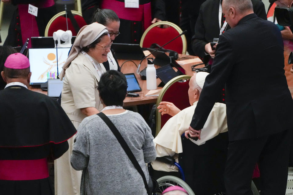 Pope Francis is greeted by women participants into the opening session of the 16th General Assembly of the Synod of Bishops as he arrives in the Paul VI Hall at The Vatican, Wednesday, Oct. 4, 2023. Pope Francis is convening a global gathering of bishops and laypeople to discuss the future of the Catholic Church, including some hot-button issues that have previously been considered off the table for discussion. Key agenda items include women's role in the church, welcoming LGBTQ+ Catholics, and how bishops exercise authority. For the first time, women and laypeople can vote on specific proposals alongside bishops. (AP Photo/Gregorio Borgia)