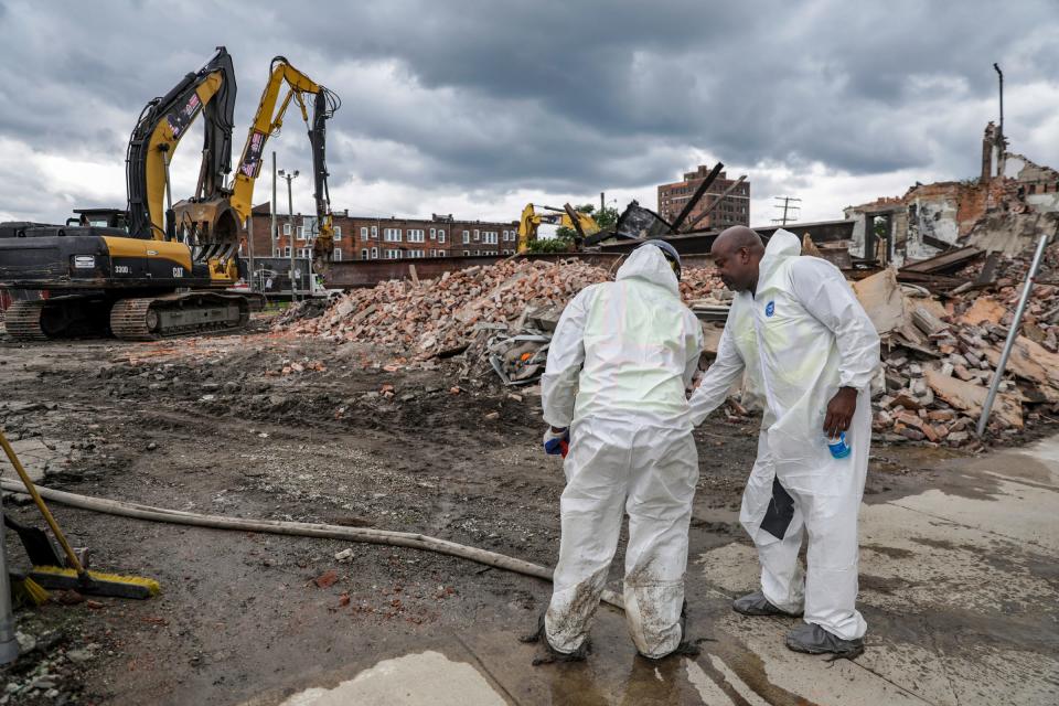 The demolition crew wears Tyvek suits because of the presence of asbestos while they tear down the building at 3143 Cass avenue is demolished in midtown Detroit on Saturday, July 29, 2023. 