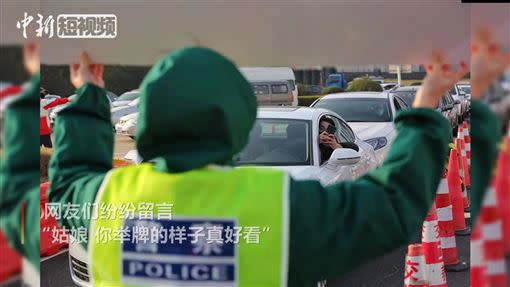 駕駛看到女警舉牌，紛紛搖下車窗替她加油打氣。（圖／翻攝自CHINA LIVE YouTube）