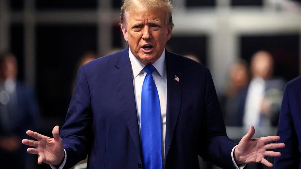 Donald Trump speaking to media, in dark blue coat, bright blue tie