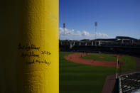 Baseball fans sign a pole near the Green Monster seating area during a spring training baseball game with the Atlanta Braves and the Boston Red Sox on Monday, March 1, 2021, in Fort Myers, Fla. (AP Photo/Brynn Anderson)
