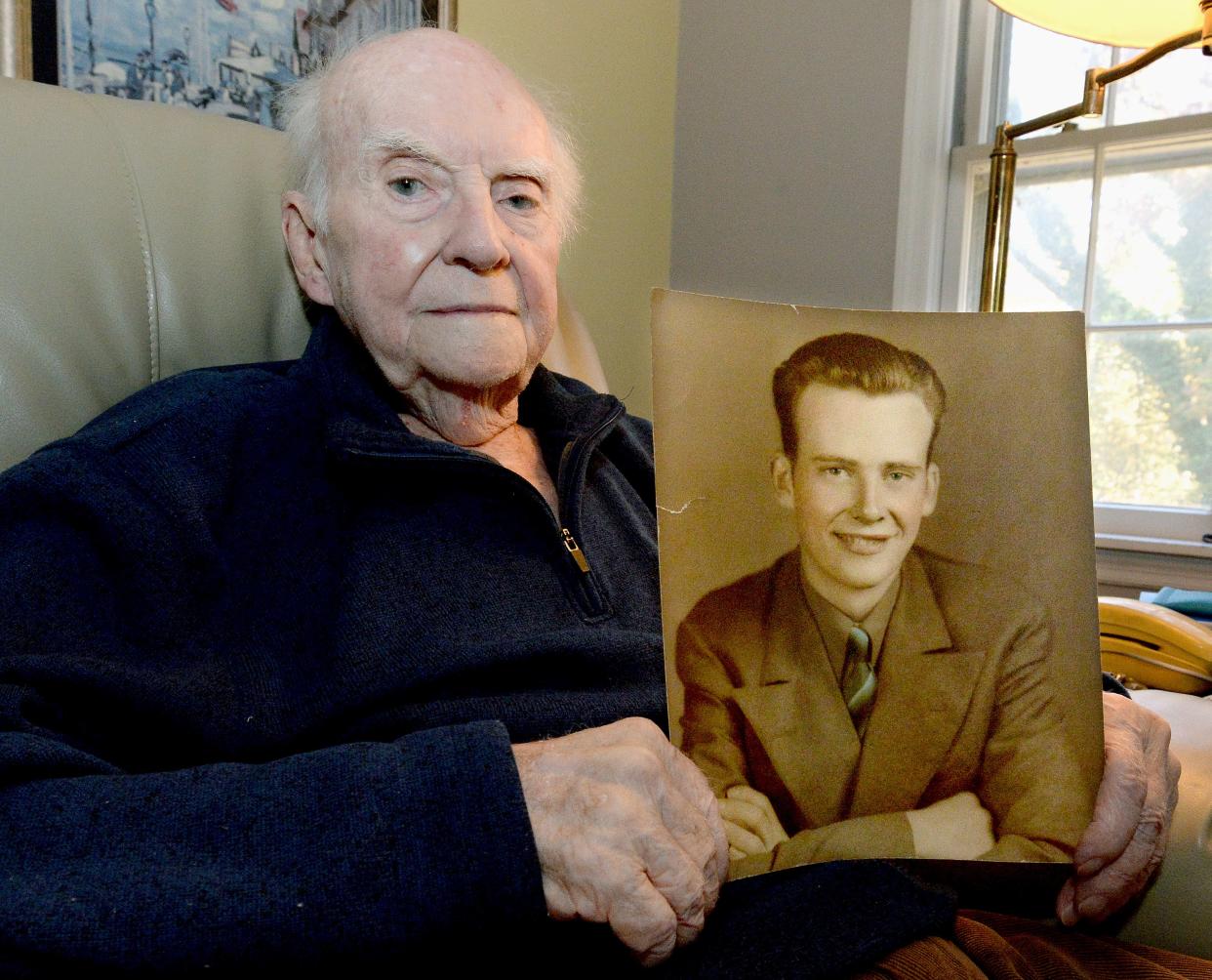 World War II veteran George Parnell of Springfield holds up a portrait of himself at his home on Wednesday Nov. 1, 2023. The photo was taken in 1943, shortly before he was drafted into the war.