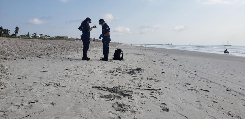 Coast Guard members examine tar-like substance tat washed up on a beach in Cape Canaveral on June 29.
(Credit: Photo provided)