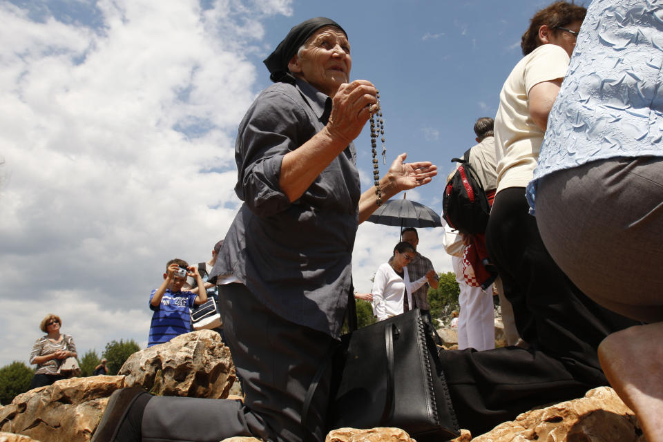 Pilgrims say prayers at the 'Hill of Appearance' in the southern-Bosnian town of Medjugorje, 100 kms south of Sarajevo, on Friday, June 25, 2010, where it is believed that the Virgin Mary showed herself and conveyed messages of peace to six children on June 25, 1981. On Friday, May 17, 2024, the Vatican will issue revised norms for discerning apparitions "and other supernatural phenomena," updating a set of guidelines first issued in 1978. (AP Photo/Amel Emric, File)