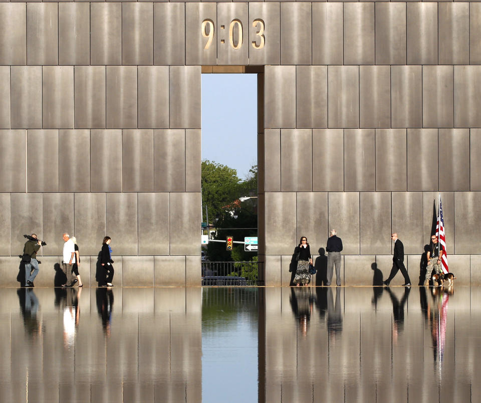 FILE - This April 19, 2012 file photo shows people walking at the Oklahoma City National Memorial and Museum before the start of the 17th annual remembrance ceremony in Oklahoma City. The memorial is where visitors can pay tribute to the people who were killed and those who survived the bombing at the Alfred P. Murrah Federal Building on April 19, 1995. While the Memorial Museum has an admission fee, the outdoor memorial, full of symbolism, is free and open year round. (AP Photo/Sue Ogrocki)