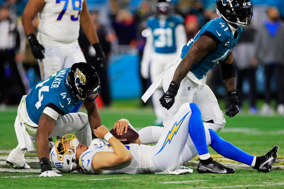 Jacksonville Jaguars linebacker Travon Walker (44) and linebacker Josh Allen (41) get up from a sack on Los Angeles Chargers quarterback Justin Herbert (10) during the second quarter of an NFL first round playoff football matchup Saturday, Jan. 14, 2023 at TIAA Bank Field in Jacksonville, Fla. The Jacksonville Jaguars edged the Los Angeles Chargers on a field goal 31-30. [Corey Perrine/Florida Times-Union]