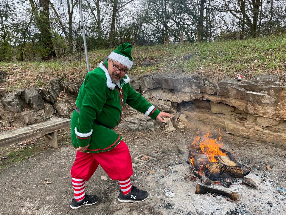 Johnny Prater, a vendor at Christmas in the Cave held at the Historical Cherokee Caverns, warms himself by the fire Sunday, Dec. 4, 2022.