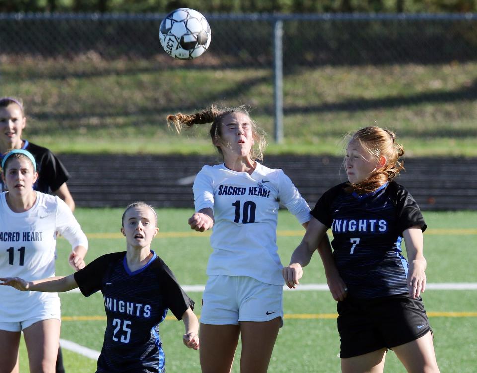 Sacred Heart's Mallory Glass (10) heads the ball between Lexington Catholic's Sophie Skinner (25) and Kylie Archer (7) during the KHSAA Girl's Soccer championship game in Lexington, Saturday, Oct. 31.