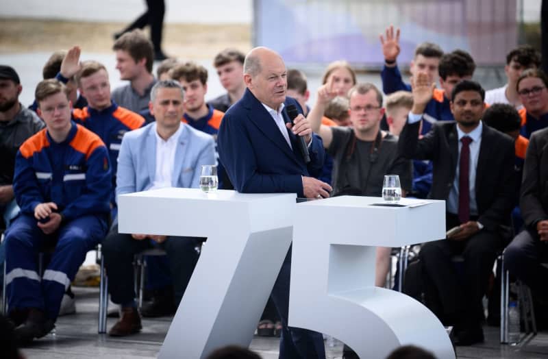 Germany's Chancellor Olaf Scholz (C) takes part in a citizens' dialog in the Dialogue Forum as part of the citizens' festival and celebrations to mark "75 years of the Basic Law". Bernd von Jutrczenka/dpa