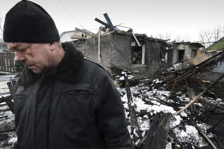 A man stands next to his house, destroyed by shelling in the Kuibishevskiy district of the eastern Ukrainian city of Donetsk, on December 9, 2014