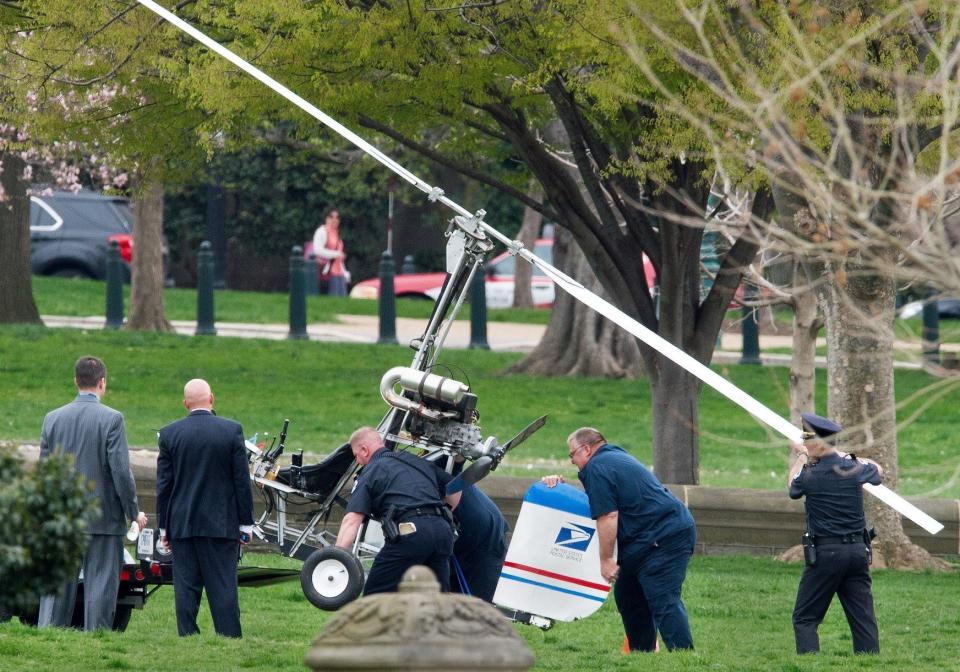 Capitol Hill police officers and other officials lift a gyrocopter that landed on the U.S. Capitol's South Lawn, onto a trailer on April 15, 2015. A man identified as Doug Hughes, 61, illegally landed his aircraft on the Capitol lawn, triggering street closures around the building and prompting a police investigation. Hughes is described as a mailman, and a logo appearing to be that of the U.S. Postal Service was visible on the tail fin of the aircraft. 