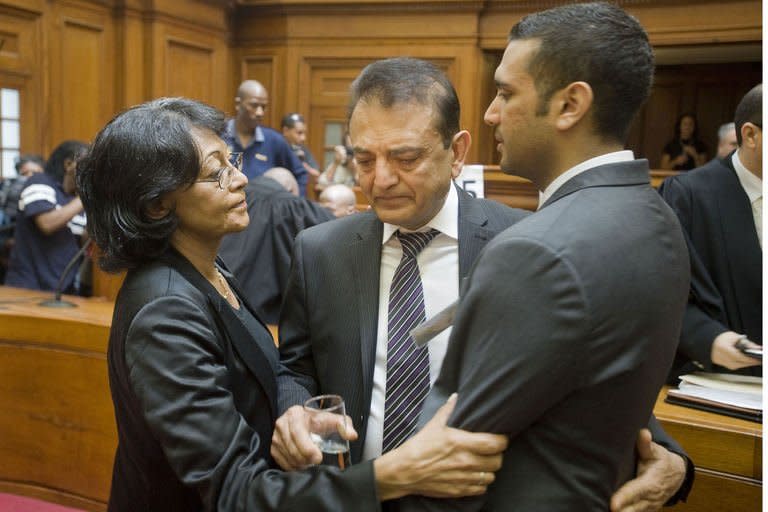Vinod Hindocha (centre) father of murdered honeymooner Anni Dewani and his son Anish (R) are comforted by a police officer in the High Court in Cape Town. A man convicted of murdering Anni Dewani in South Africa two years ago has been sentenced to life in prison