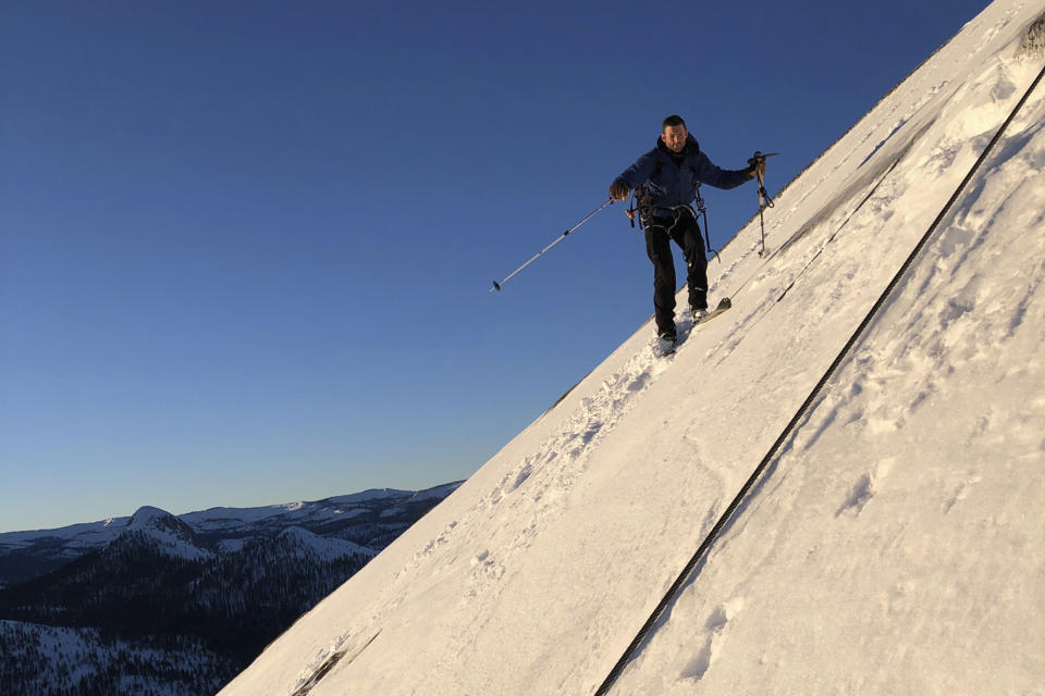 In this photo provided by Jason Torlano, Zach Milligan is shown on his descent down Half Dome in Yosemite National Park, Calif., on Sunday, Feb. 21, 2021. Two men climbed some 4,000 feet to the top of Yosemite's Half Dome in subfreezing temperatures and skied down the famously steep monolith to the valley floor. Jason Torlano, 45, and Zach Milligan, 40, completed the daring descent in five hours on Sunday by charging down Half Dome's arching back and using ropes to rappel down several sections of bare rock known as the "death slabs," the Fresno Bee reported on Thursday. (Jason Torlano via AP)