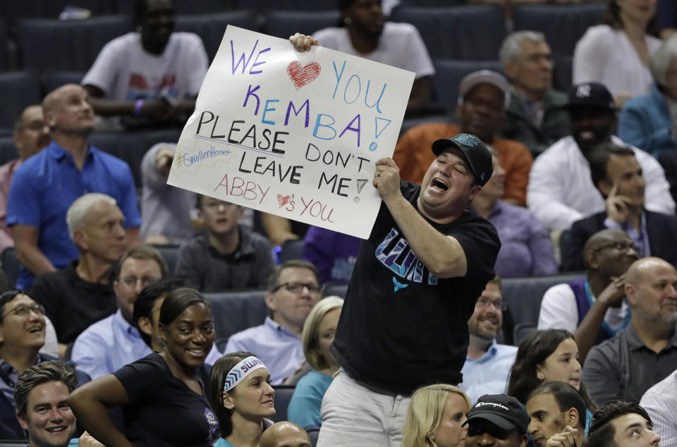 A Charlotte Hornets fan holds up a sign begging Kemba Walker to stay in Charlotte, during the second half of the team's NBA basketball game against the Orlando Magic in Charlotte, N.C., Wednesday, April 10, 2019. (AP Photo/Chuck Burton)