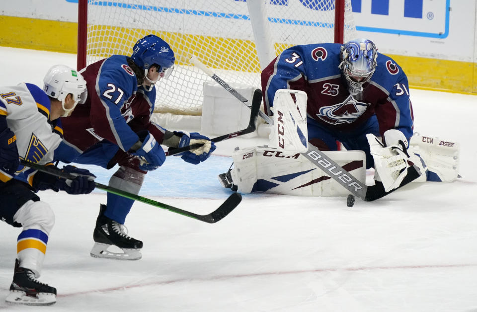 Colorado Avalanche goaltender Philipp Grubauer, right, stops a shot by St. Louis Blues left wing Jaden Schwartz, left, as Colorado defenseman Ryan Graves watches during the first period of an NHL hockey game Wednesday, Jan. 13, 2021, in Denver. (AP Photo/David Zalubowski)