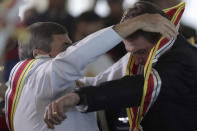 FILE - Brazil's President Jair Bolsonaro puts out his arm to receive the Order of Military Judicial Merit from Adm. Marcus Vinicius Oliveira dos Santos, in Brasilia, Brazil, March 28, 2019. Bolsonaro, a former army captain, has accumulated medals of varying importance in the three years since he took office, mostly from the armed forces. (AP Photo/Eraldo Peres, File)