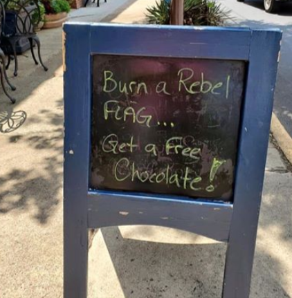 A chocolate shop owner posted a sign outside his store in response to a group of people who were waving Confederate flags (Credit: Facebook)