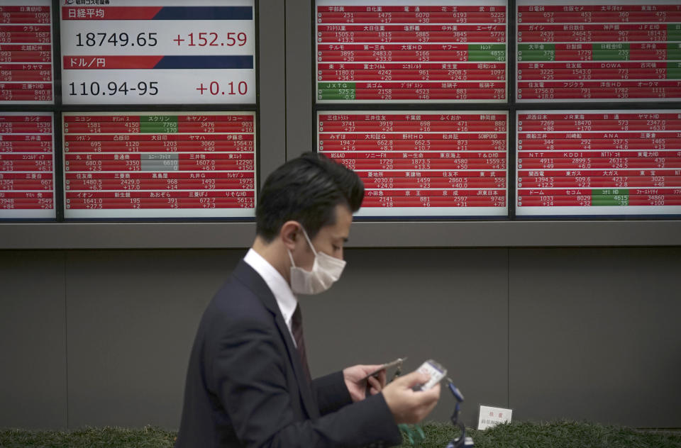 A man walks past an electronic stock board showing Japan's Nikkei 225 index at a securities firm in Tokyo, Friday, April 7, 2017. Asian stock indexes sank Friday as the U.S. fired missiles at a Syrian air base during President Donald Trump's first meeting with China's president, leaving investors on edge over the global outlook. (AP Photo/Eugene Hoshiko)