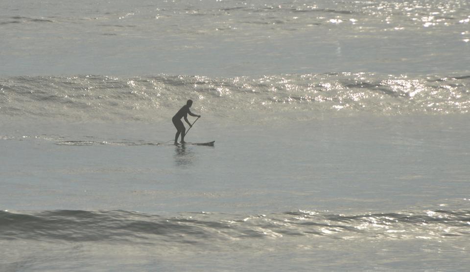 A paddleboarder takes advantage of the rolling waves on Wednesday off Coast Guard Beach in Eastham, ahead of the expected effects along the Cape's Atlantic coastline from Hurricane Lee.