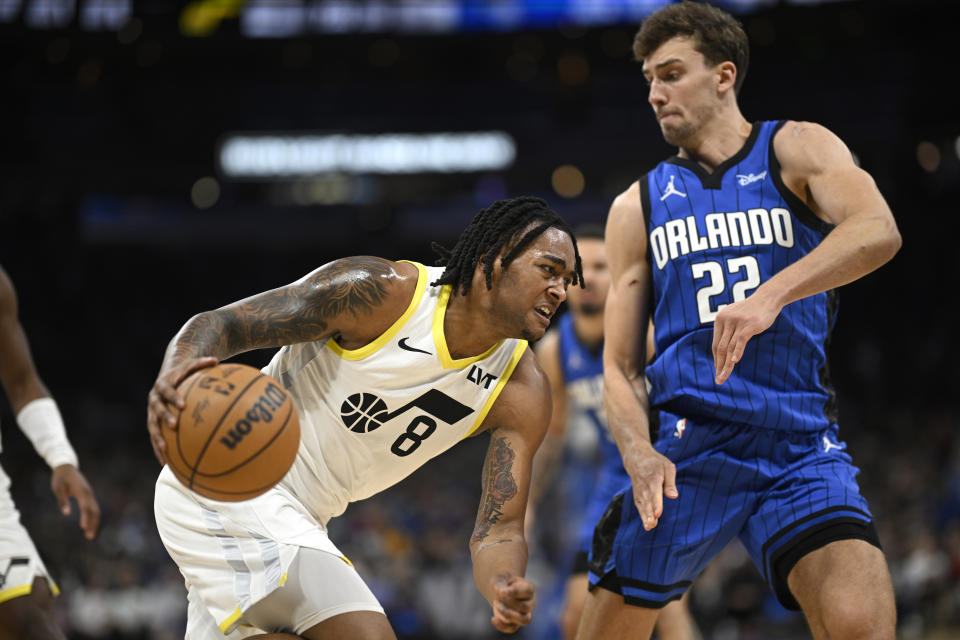 Utah Jazz forward Brice Sensabaugh (8) drives to the basket as Orlando Magic forward Franz Wagner (22) defends during the first half of an NBA basketball game, Thursday, Feb. 29, 2024, in Orlando, Fla. (AP Photo/Phelan M. Ebenhack)