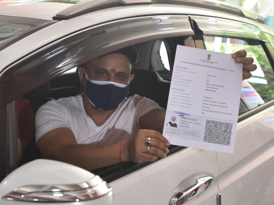 NEW DELHI, INDIA - MAY 29: A beneficiary showing certificate after a shot of Covishield dose vaccine at Chhatrasal Stadium, on May 29, 2021 in New Delhi, India. Arvind Kejriwal said the Delhi government has floated a global tender for vaccines and is making all efforts from its side, but big vaccine manufacturing companies want to deal with the Centre directly. (Photo by Sonu Mehta/Hindustan Times via Getty Images)