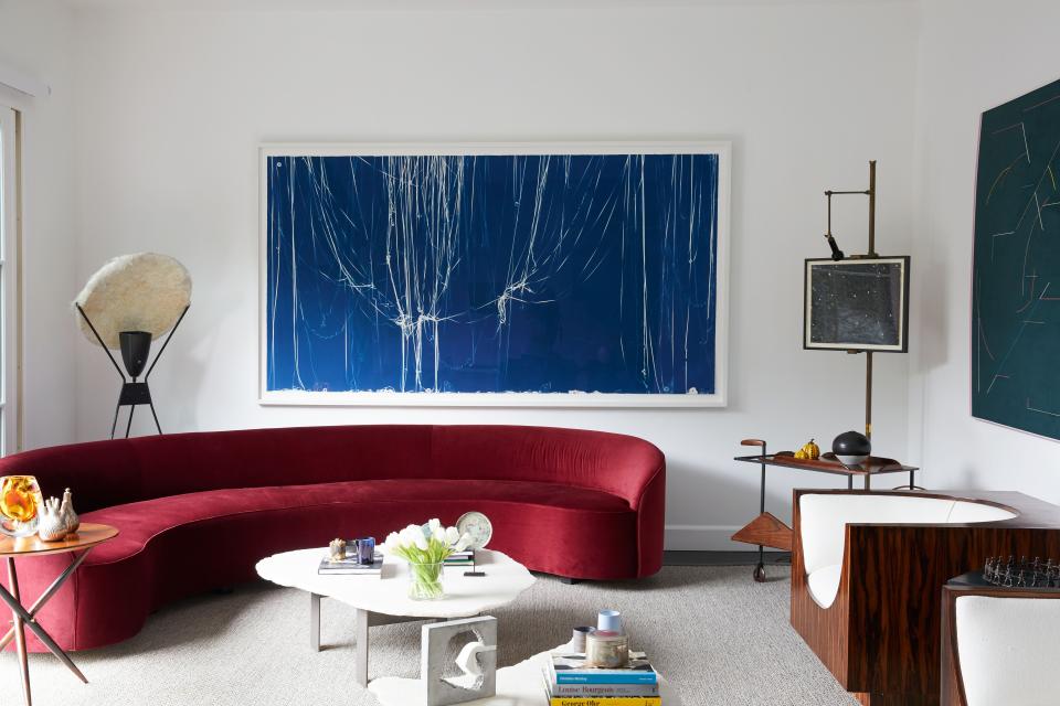 In the living room, a curvaceous sofa by Brazilian studio Neobox pairs nicely with Jorge Zalszupin’s Cube chairs from the 1960s, made in richly veined jacarandá wood. The large blue artwork is a cyanotype by Swiss-American artist Christian Marclay. To the right, we see a 1950s easel by Angelo Lelli holding a Fred Tomaselli photogram, and a Zalszupin tea trolley.