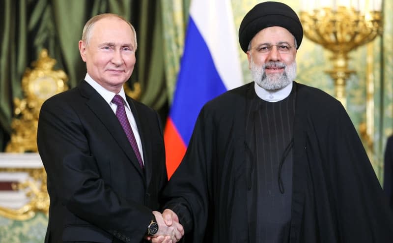 Russian President Vladimit Putin (L) shakes hands meets Iranian President Ebrahim Raisi (R) ahead of their meeting at Kremlin. -/Kremlin/dpa