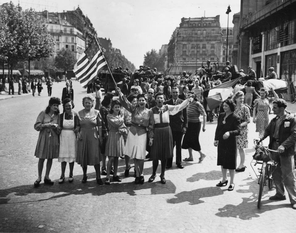 FILE - In this Aug. 25, 1944 file photo, French civilians with hastily made American and French flags greet U.S. and Free French troops entering Paris, France, after Allied liberation of the French capital from Nazi occupation in World War II. For Allied troops in western Europe, D-Day was just the beginning of a long and bloody push toward victory over the Nazis. Ten weeks after commemorating the 75th anniversary of the D-Day invasion in Normandy, France is paying tribute this week to Allied troops involved in another major, but often overlooked, military operation: landings on the Mediterranean coast. (AP Photo/Harry Harris, file)