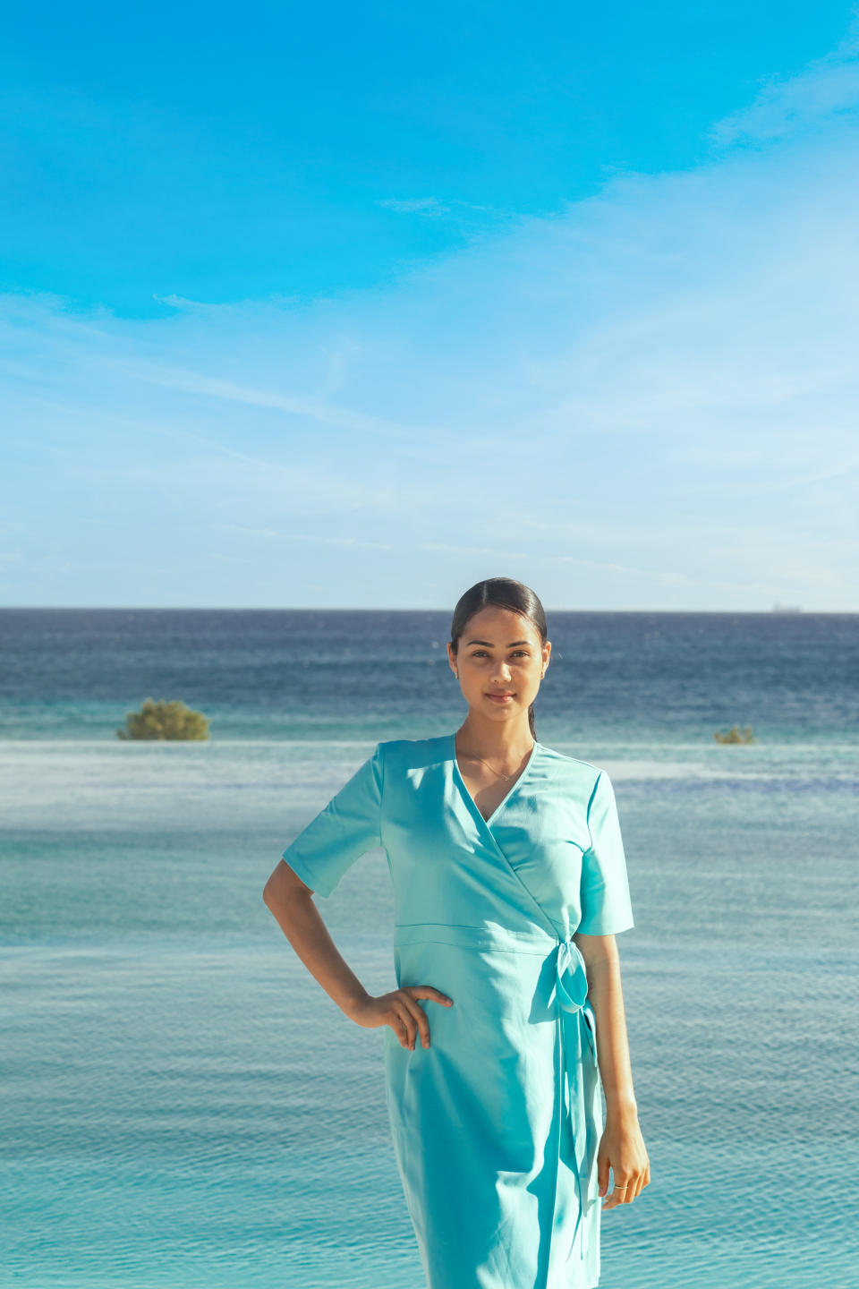 A Sandals Royal Curaçao cocktail server wears a Stan Herman-designed dress.