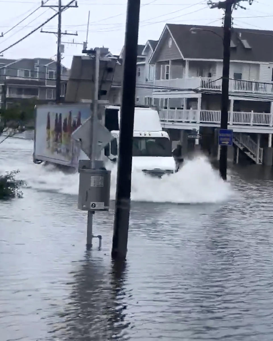 A tractor-trailer plows through standing water on a flooded Sea Isle City street, on New Jersey's Long Beach Island, Friday, July 10, 2020, in this photo made from video provided by Anthony Kutschera Jr. The Jersey shore was lashed Friday as the fast-moving Tropical Storm Fay churned north on a path expected to soak the New York City region. (Anthony Kutschera Jr. via AP)