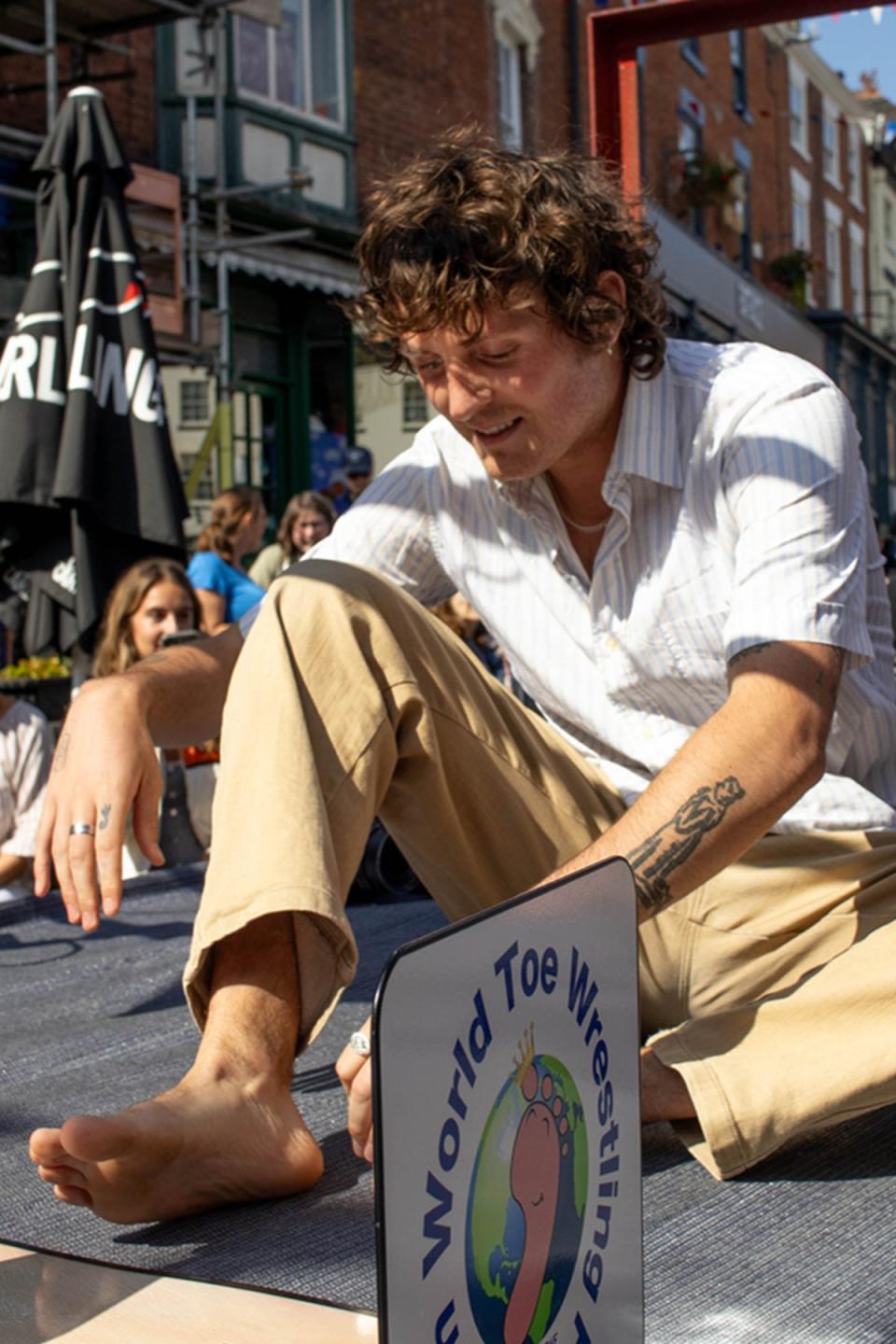 Toeing the line: A competitor prepares his feet for wrestling (Elizabeth McCafferty)