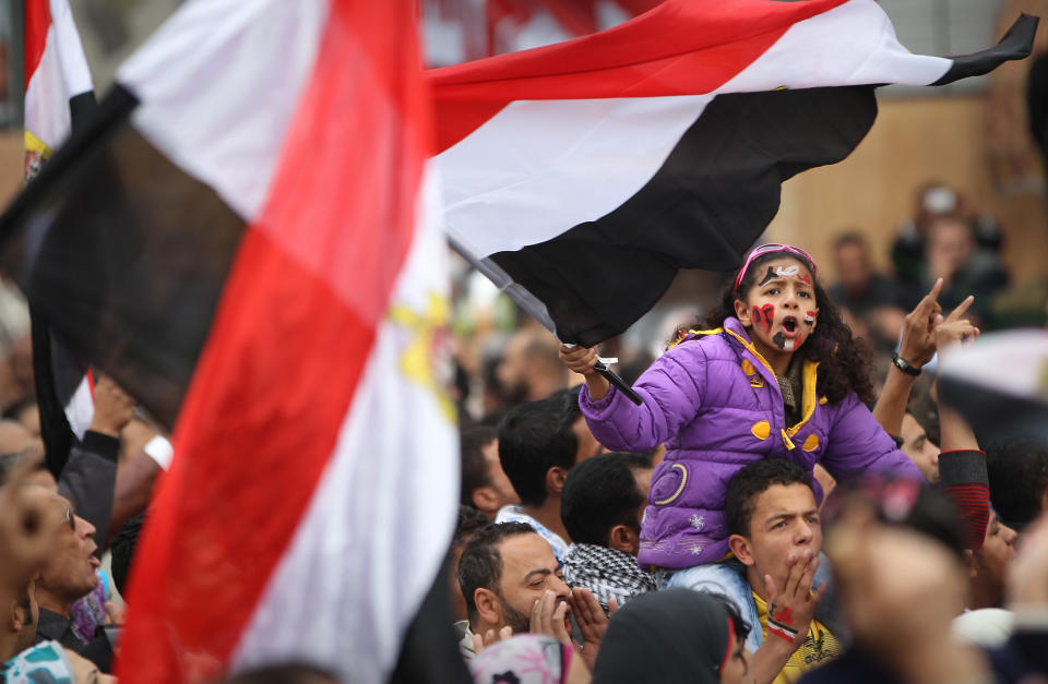 CAIRO, EGYPT - NOVEMBER 27: A girl chants and waves a flag as she and other protestors remain in Tahrir Square on November 27, 2011 in Cairo, Egypt Protestors are continuing to occupy Tahrir Square ahead of parliamentary elections to be held tomorrow. (Photo by Peter Macdiarmid/Getty Images)