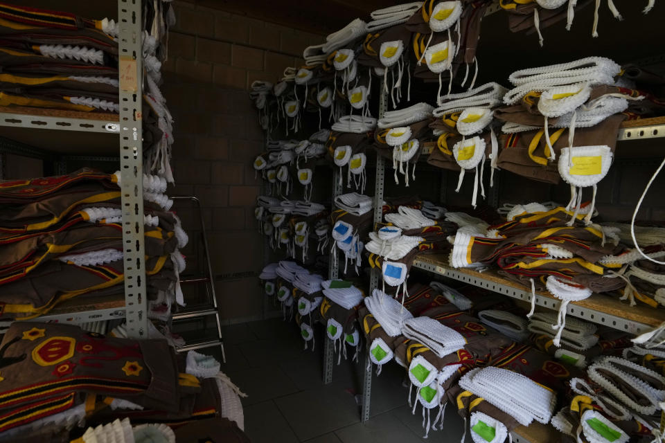 Costumes labelled with names are stacked on a shelf at the Kersten family costume workshop in Binche, Belgium, Wednesday, Feb. 1, 2023. After a COVID-imposed hiatus, artisans are putting finishing touches on elaborate costumes and floats for the renowned Carnival in the Belgian town of Binche, a tradition that brings together young and old and is a welcome moment of celebration after a rough few years. (AP Photo/Virginia Mayo)