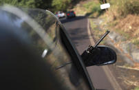 A weapon sticks out from a window as members of the so-called self-defense group known United Towns or Pueblos Unidos, gather for a rally in Nuevo Urecho, in the Mexican western state of Michoacan, Saturday Nov. 27, 2021. Extortion of avocado growers in western Mexico has gotten so bad that 500 vigilantes from the "self-defense" group gathered Saturday and pledged to aid police. (AP Photo/Armando Solis)