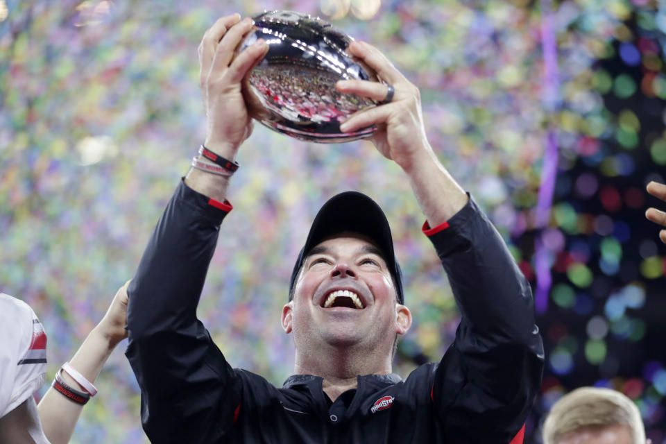 Ohio State coach Ryan Day holds the trophy following the team's 34-21 win over Wisconsin in the Big Ten championship NCAA college football game, early Sunday, Dec. 8, 2019, in Indianapolis. (AP Photo/Michael Conroy)