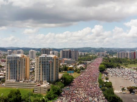 People gather along a main highway during a protest calling for the resignation of Governor Ricardo Rossello in San Juan