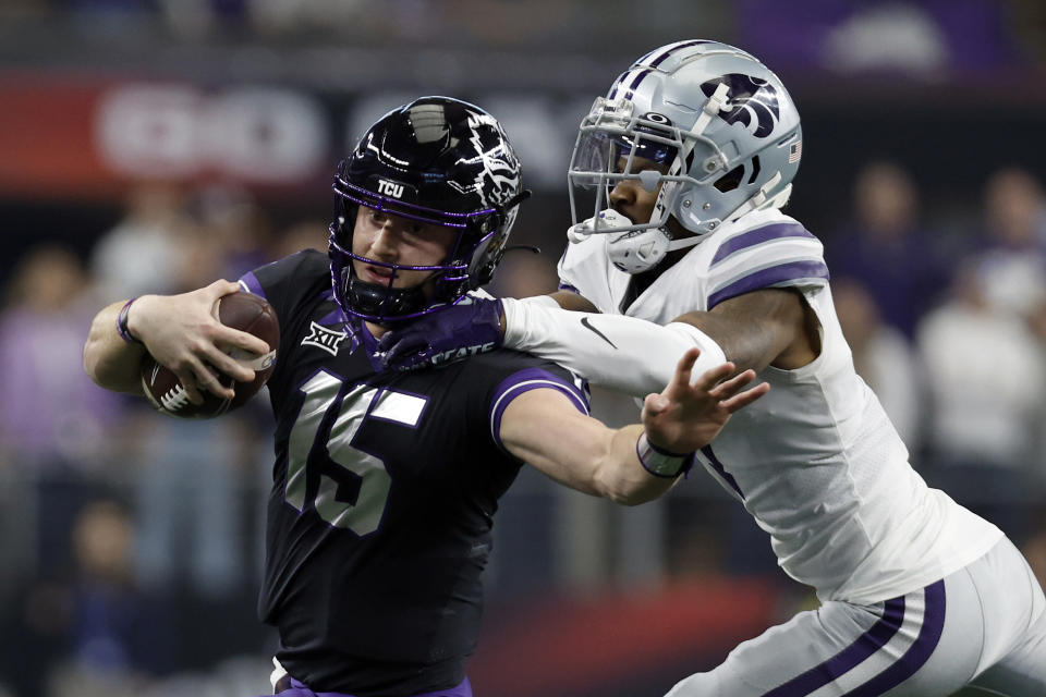 ARLINGTON, TEXAS - DECEMBER 03: Quarterback Max Duggan #15 of the TCU Horned Frogs is tackled by safety Josh Hayes #1 of the Kansas State Wildcats in the first quarter at AT&T Stadium on December 03, 2022 in Arlington, Texas. (Photo by Tim Heitman/Getty Images)