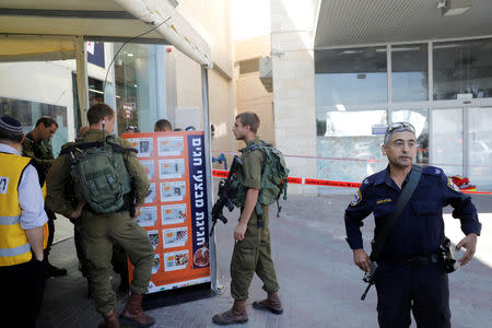 Israeli soldiers and a policeman work at the scene of a stabbing attack near a mall in the Gush Etzion Junction in the occupied West Bank, September 16, 2018. REUTERS/Ronen Zvulun