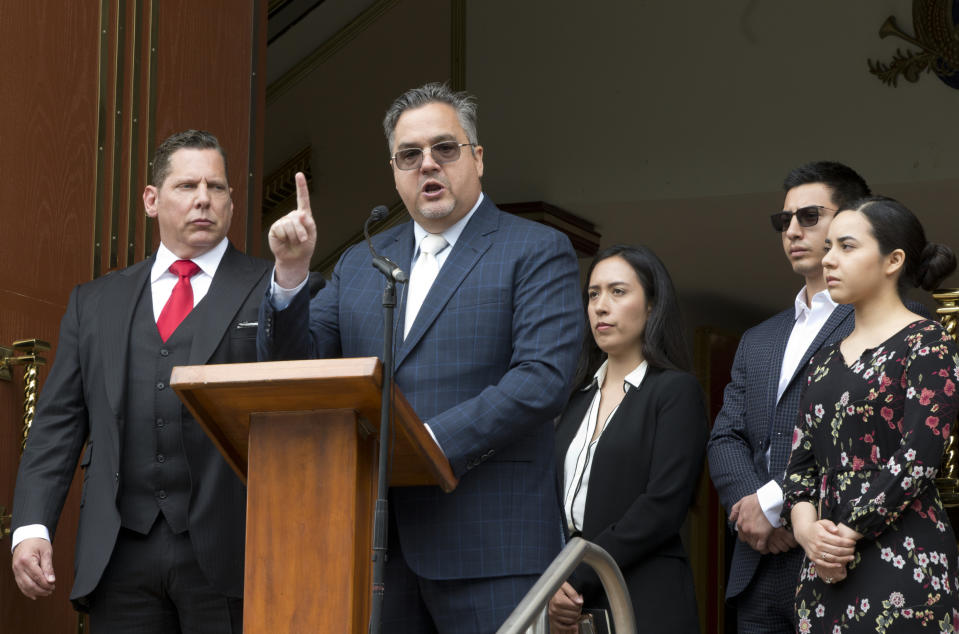New lawyers for the leader of a Mexico-based megachurch charged with human trafficking and child rape, attorneys Ken Rosenfeld, far left, and Allen Sawyer, at podium, say La Luz del Mundo leader Naasón Joaquín García and his family are paying their legal fees and the prosecutor's fears that church followers could raise his $50 million bail are unfounded, during a news conference outside the East Los Angeles temple of La Luz del Mundo Friday, June 7, 2019. (AP Photo/Damian Dovarganes)