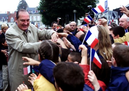 FILE PHOTO: File photo of French President Jacques Chirac shaking hands with residents of Saint-Amand Montrond near Bourges..