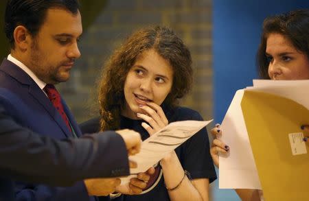 Students speak to a teacher as they receive their A- level results at the Harris City Academy in London, Britain August 18, 2016. REUTERS/Peter Nicholls