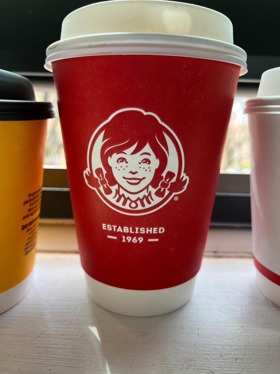 cup of wendy's coffee sitting on a window ledge
