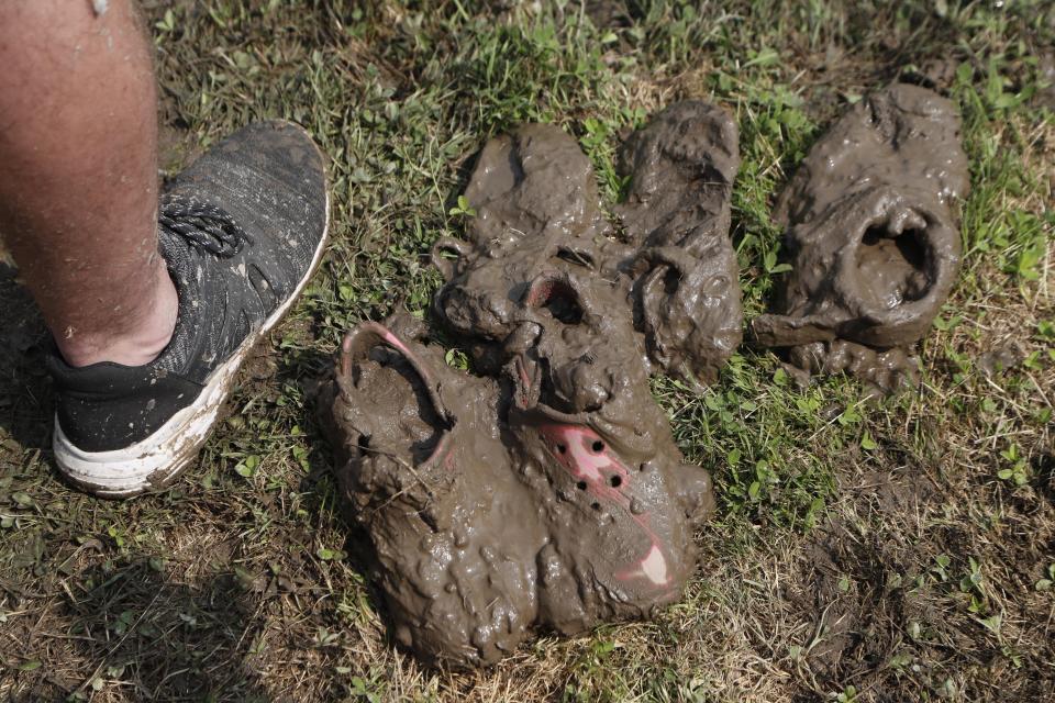 Mud covered shoes are seen on the sidelines during Mud Day at the Nankin Mills Park, Tuesday, July 9, 2019, in Westland, Mich. The annual day is for kids 12 years old and younger. While parents might be welcome, this isn't an event meant for teens or adults. It's all about the kids having some good, unclean fun during their summer break and is sponsored by the Wayne County Parks. (AP Photo/Carlos Osorio)